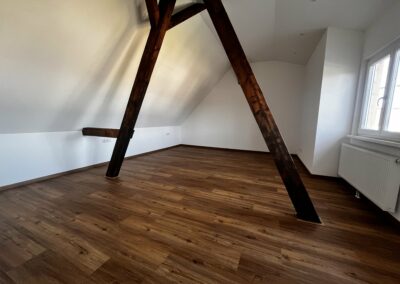 Dachboden mit passgenau verlegtem Holzboden zwischen zwei tragenden Pfetten – Schreinerarbeit von Kappus in Ettenheim