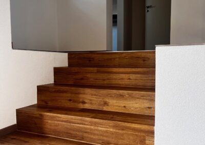 Kleine Holztreppe mit Holzboden und geöffneter weißer Tür – Innenausbau vom Schreiner Kappus in Ettenheim